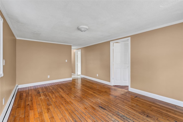 empty room featuring hardwood / wood-style flooring, baseboards, baseboard heating, and ornamental molding