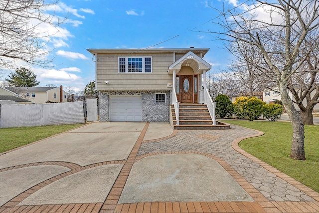 view of front of property with a front yard, fence, driveway, an attached garage, and brick siding