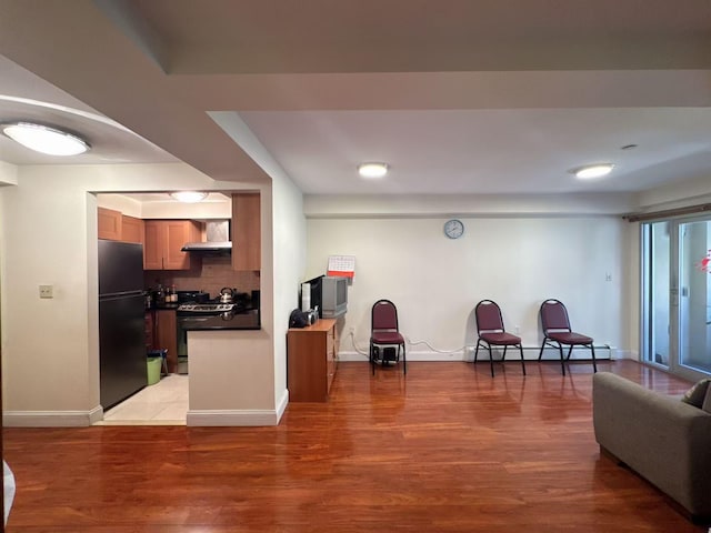 kitchen with tasteful backsplash, dark countertops, freestanding refrigerator, range with gas cooktop, and baseboard heating