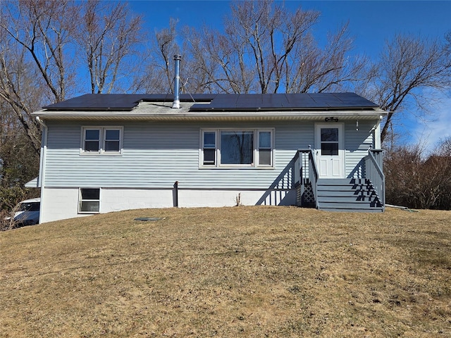 view of front of property with solar panels and a front lawn