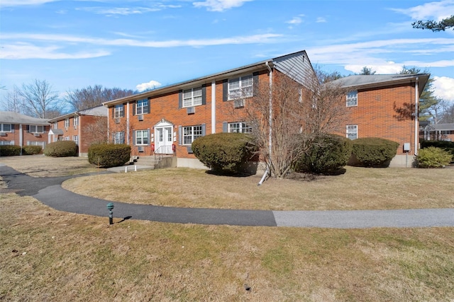 view of front of property featuring a front lawn and brick siding