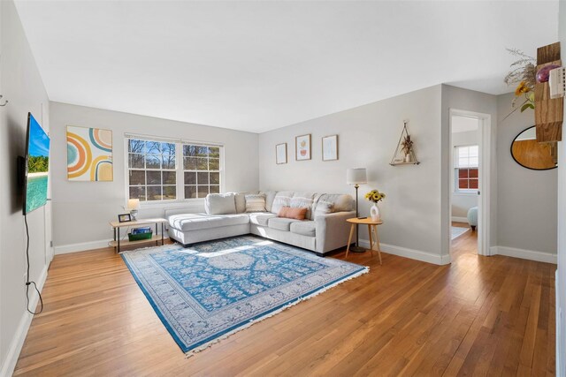 living area with light wood-style flooring and baseboards