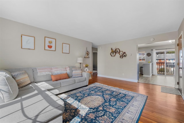 living area with baseboards and wood finished floors