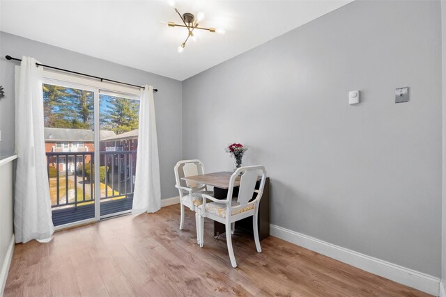 dining room with a notable chandelier, wood finished floors, and baseboards