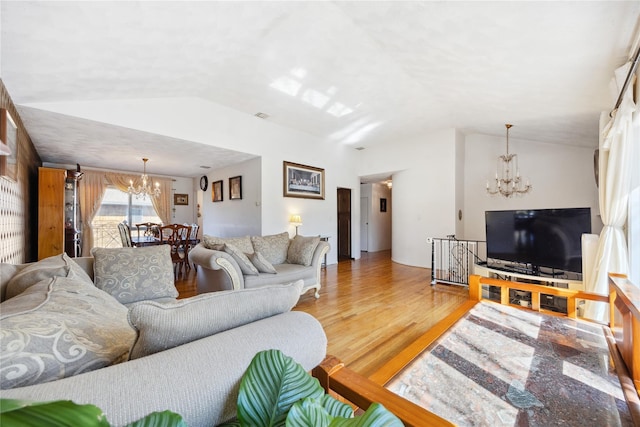 living area with lofted ceiling, a notable chandelier, and light wood-type flooring