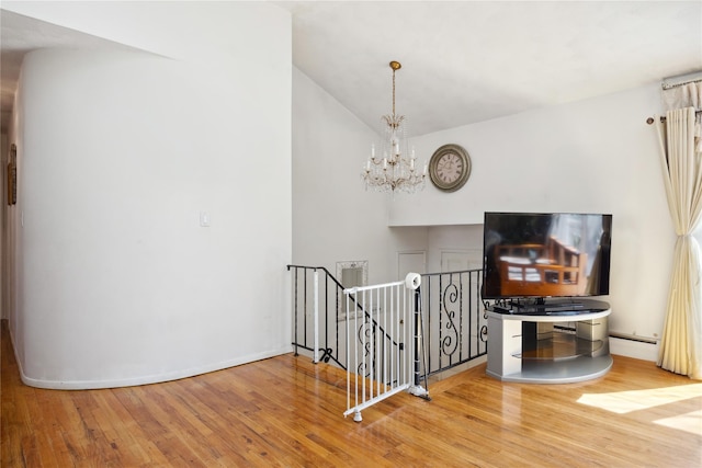 hall featuring an upstairs landing, a notable chandelier, light wood-style flooring, a baseboard radiator, and baseboards