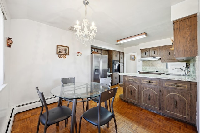 dining space featuring baseboard heating, a baseboard radiator, a notable chandelier, and visible vents