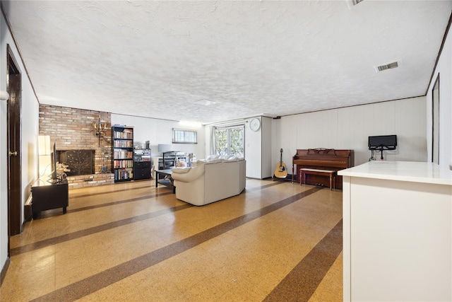 living area with tile patterned floors, a fireplace, visible vents, and a textured ceiling