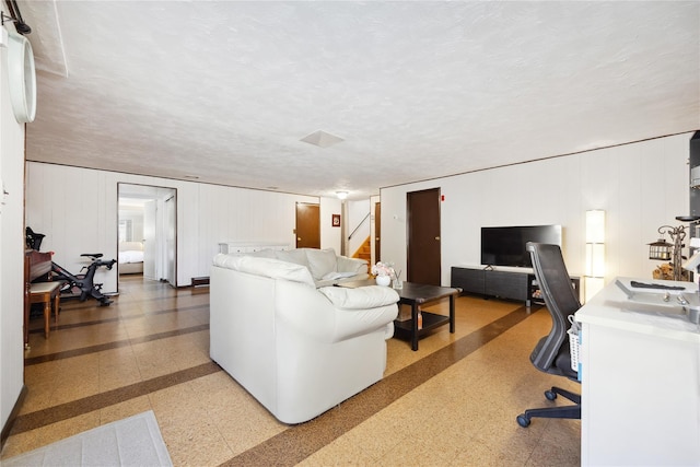 living area with stairway, light speckled floor, and a textured ceiling