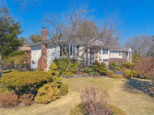 raised ranch with a chimney and a front yard