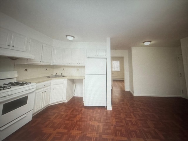 kitchen featuring white gas stove, light countertops, range hood, white cabinetry, and a sink