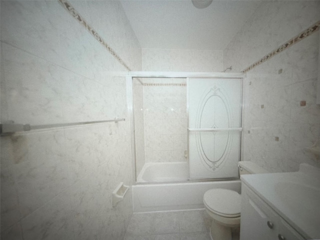 full bath with tile patterned flooring, toilet, and shower / bath combination with glass door