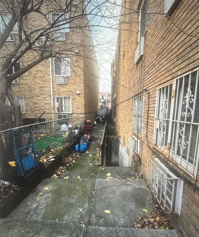 view of side of property featuring fence and brick siding