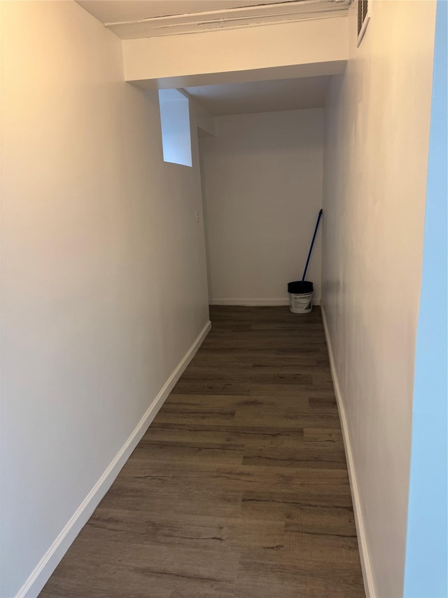 hall featuring visible vents, dark wood-style flooring, and baseboards