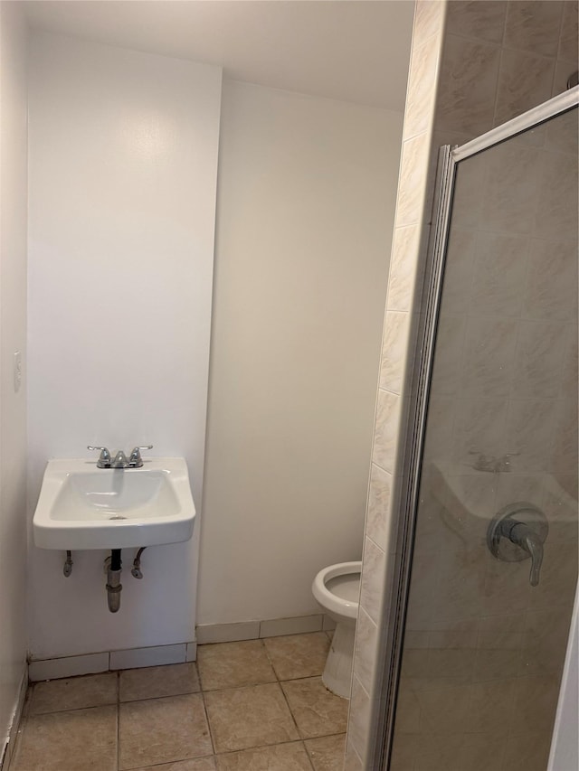 full bathroom with tile patterned floors, toilet, a stall shower, and a sink