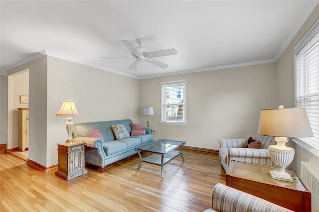 living room with a ceiling fan, plenty of natural light, and light wood-style floors