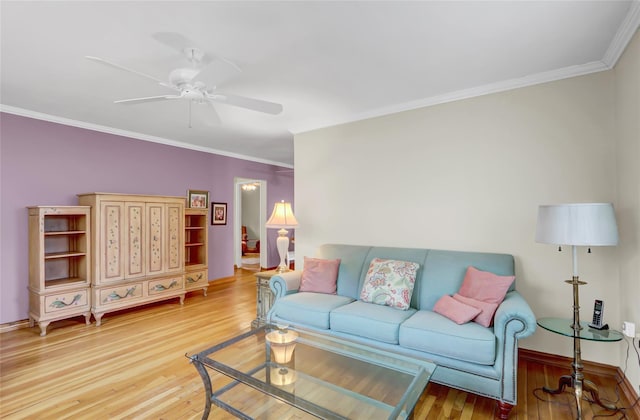 living room with crown molding, light wood-style floors, baseboards, and ceiling fan