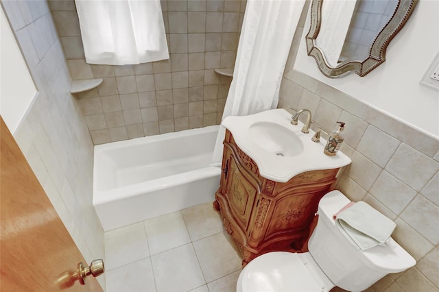 bathroom with vanity, tile patterned flooring, shower / bath combo with shower curtain, tile walls, and toilet