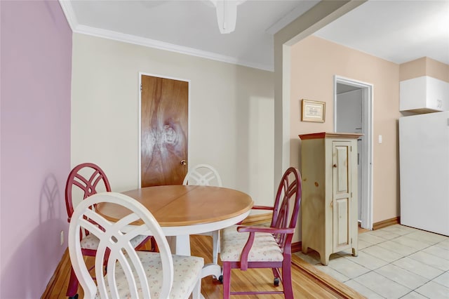 dining room featuring light tile patterned floors, baseboards, and ornamental molding