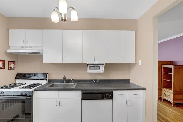 kitchen with under cabinet range hood, a sink, range with gas stovetop, dark countertops, and white dishwasher