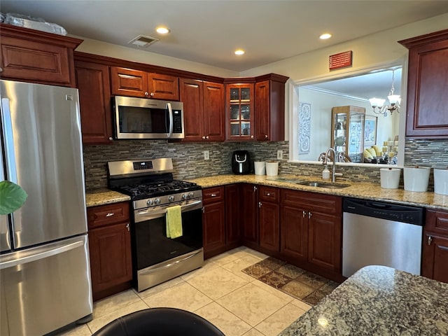 kitchen featuring tasteful backsplash, visible vents, a chandelier, stainless steel appliances, and a sink