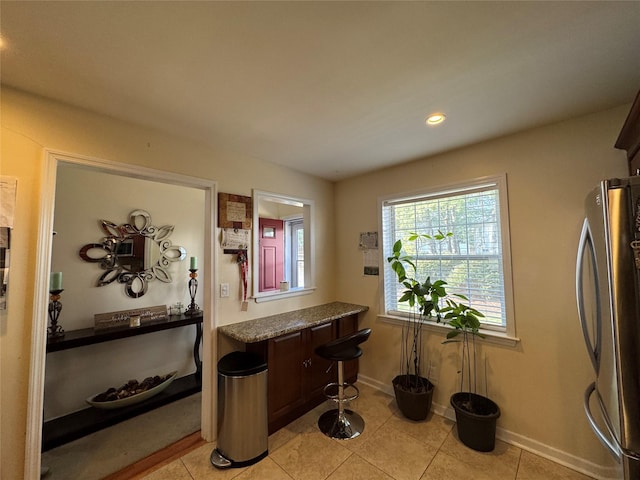 kitchen featuring light tile patterned floors, recessed lighting, baseboards, and freestanding refrigerator