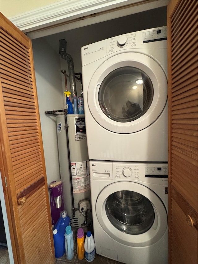 washroom featuring water heater, laundry area, and stacked washer and clothes dryer