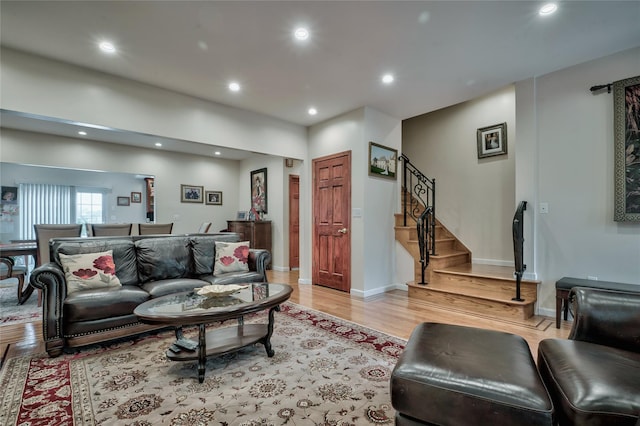 living room featuring recessed lighting, stairway, light wood-type flooring, and baseboards