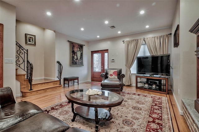 living room featuring visible vents, baseboards, stairway, recessed lighting, and light wood-style floors