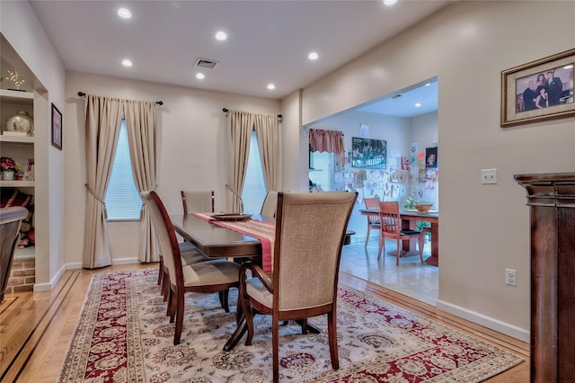 dining room featuring light wood finished floors, visible vents, recessed lighting, and baseboards