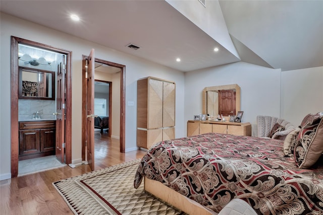 bedroom featuring light wood-style flooring, recessed lighting, visible vents, and a sink