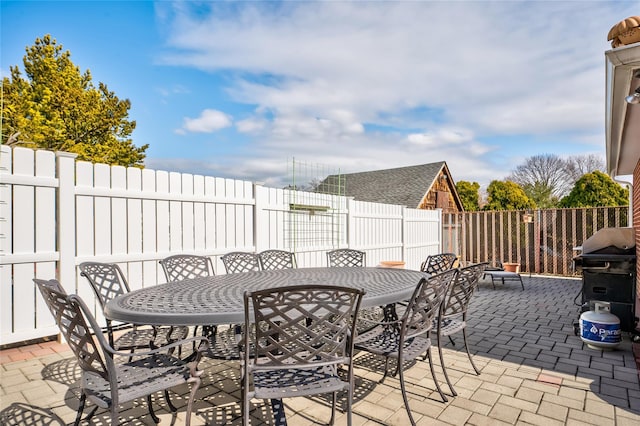 view of patio featuring outdoor dining area, area for grilling, and a fenced backyard