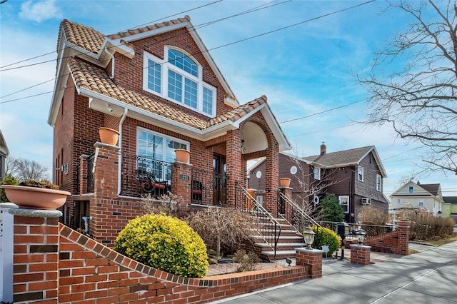 view of front of house with brick siding and a tile roof