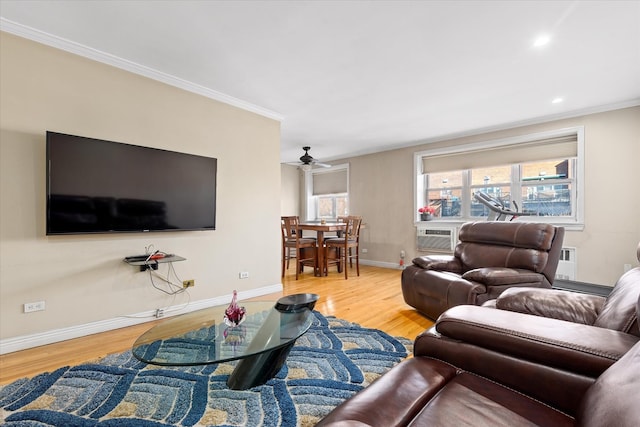 living room with crown molding, baseboards, and wood finished floors