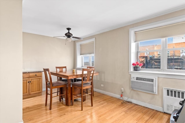 dining room featuring light wood-type flooring, plenty of natural light, an AC wall unit, and radiator heating unit