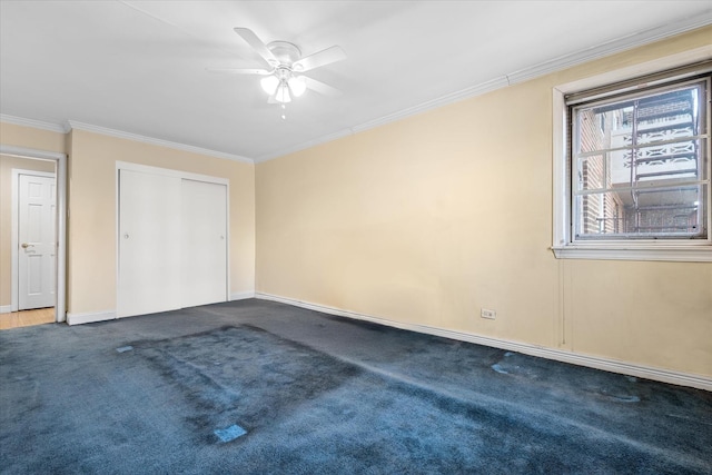 unfurnished bedroom with baseboards, ceiling fan, ornamental molding, a closet, and dark carpet