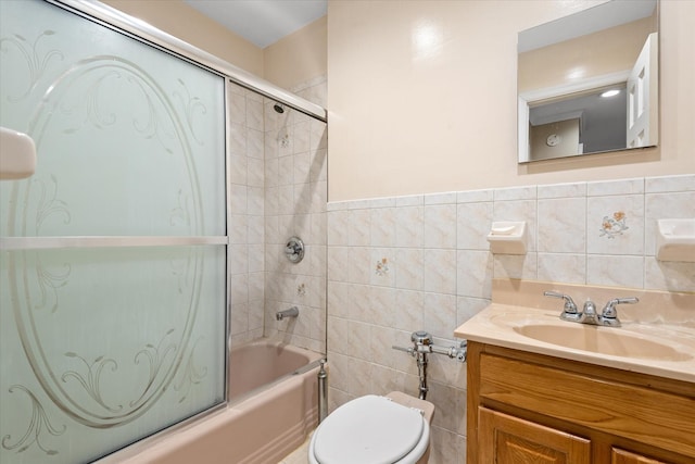 full bathroom with vanity, enclosed tub / shower combo, wainscoting, tile walls, and toilet