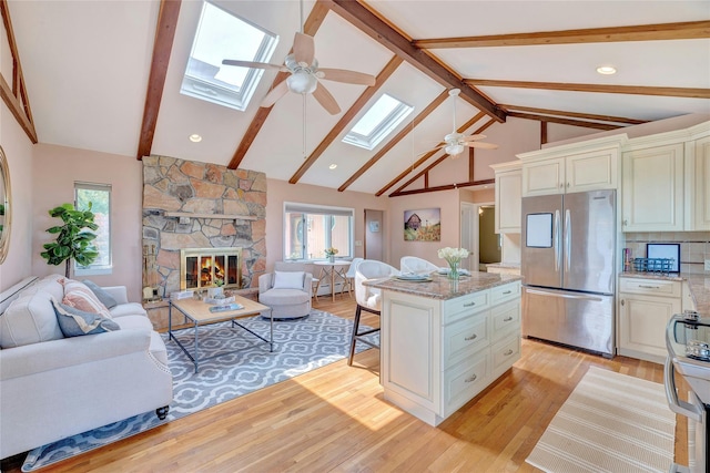 48 Crows Nest Dr, Baiting Hollow, NY 11901 - living area with a ceiling fan, a skylight, beamed ceiling, plenty of natural light, and light wood-style floors
