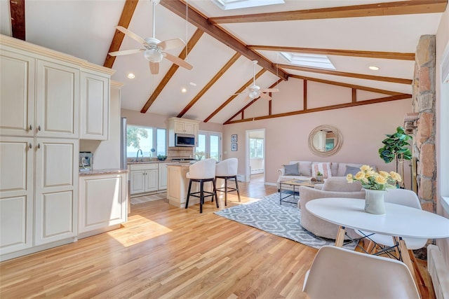 48 Crows Nest Dr, Baiting Hollow, NY 11901 - living area with a skylight, a ceiling fan, light wood-style floors, beamed ceiling, and high vaulted ceiling