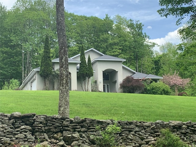 view of side of home with a yard and stucco siding