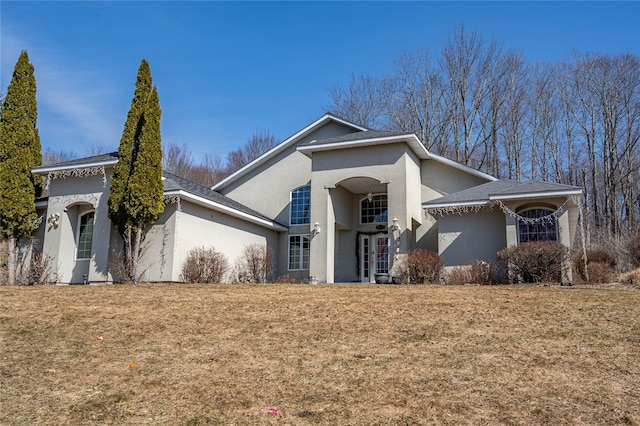 view of front facade featuring french doors, a front yard, and stucco siding
