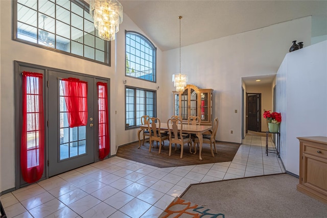 entryway with baseboards, high vaulted ceiling, light tile patterned floors, and a chandelier