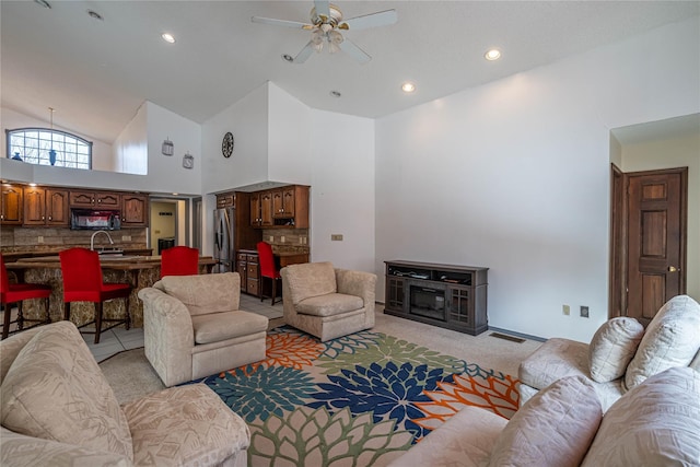living room featuring high vaulted ceiling, light carpet, visible vents, ceiling fan, and recessed lighting
