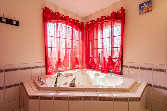 bathroom with tile walls, a textured ceiling, and a tub with jets