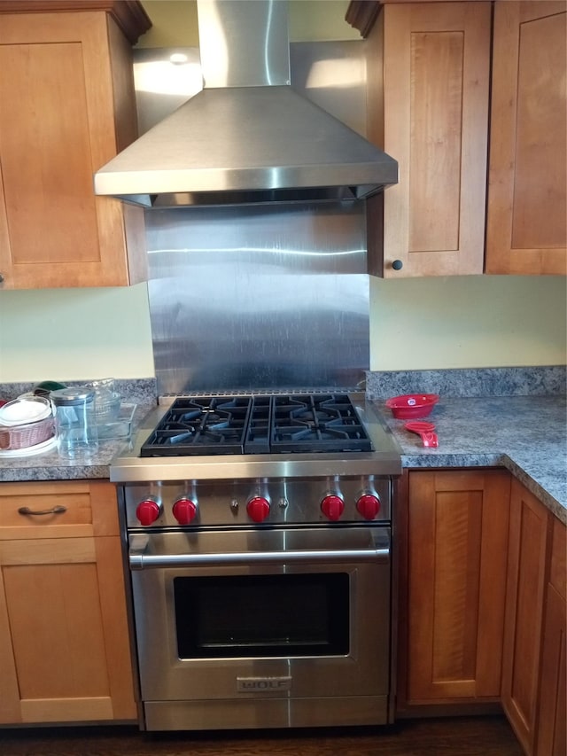 kitchen featuring light countertops, wall chimney range hood, premium range, and backsplash