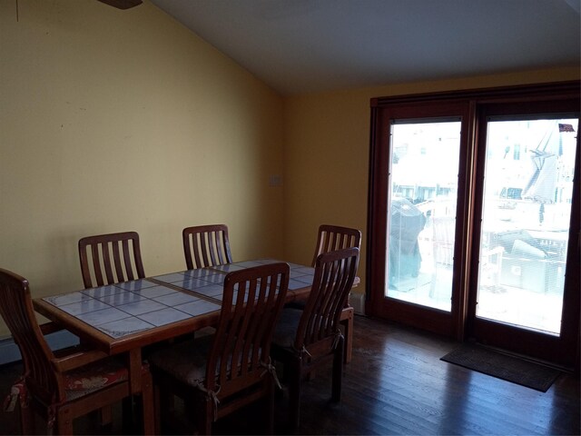 dining area featuring lofted ceiling and wood finished floors