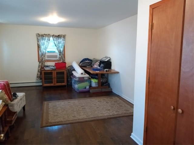 interior space with a baseboard heating unit, cooling unit, wood finished floors, and baseboards