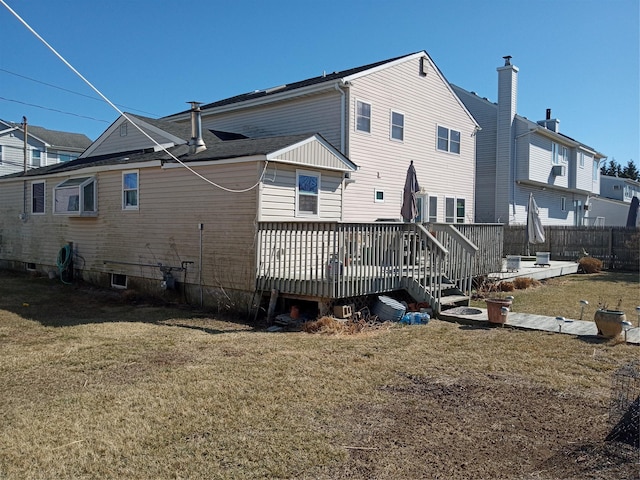 rear view of house featuring a lawn and a wooden deck