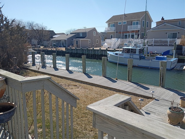 view of dock with a residential view and a water view