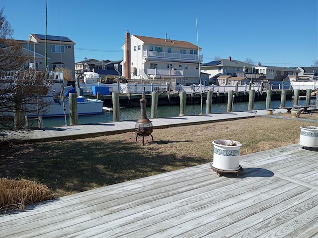 view of dock with a yard, a residential view, and a water view